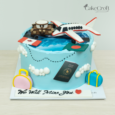 Travel-themed farewell cake with an airplane, suitcase, passport, Canadian and Bangladeshi flags, and luggage against a light blue fondant background.