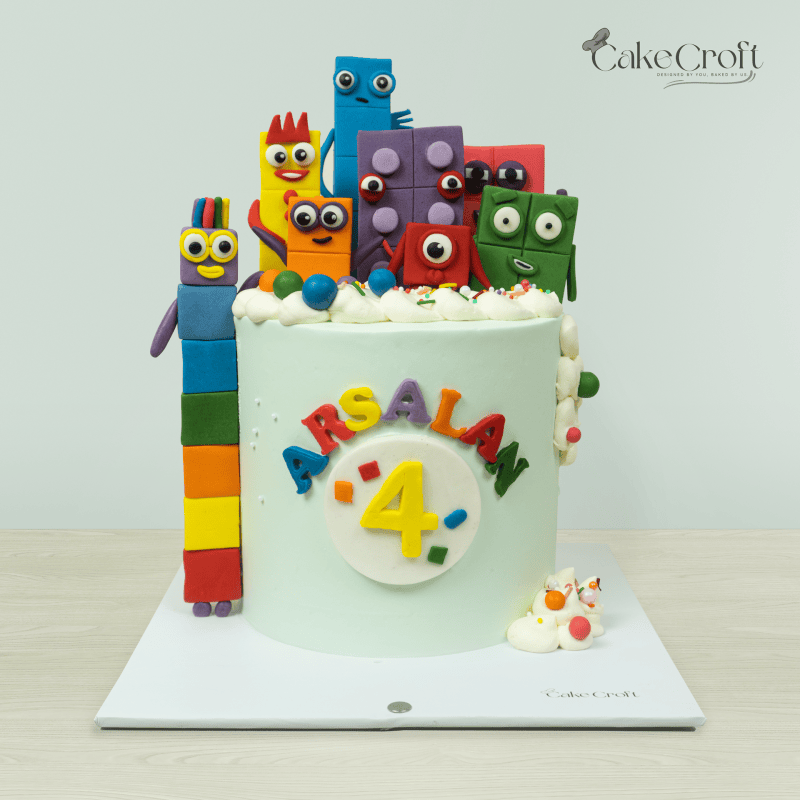 Colorful number-themed birthday cake for a 4-year-old, featuring block characters and personalized name.