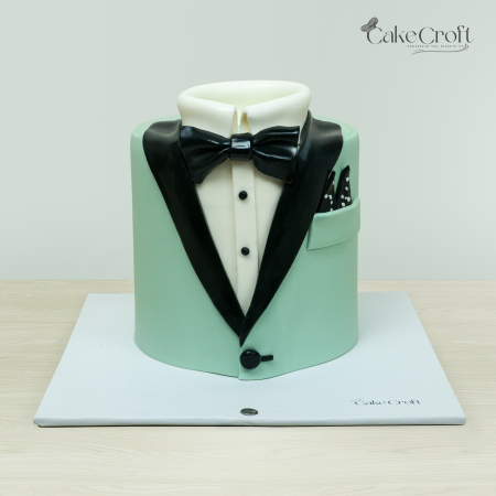 Tuxedo-themed cake with mint green jacket, black bow tie, and lapel by Cakecroft, perfect for formal celebrations