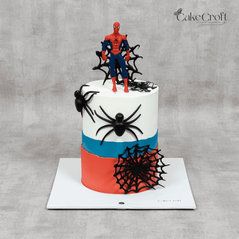 A Spider-Man-themed cake with a red, blue, and white color scheme, decorated with black fondant spiders, intricate edible web designs, and a Spider-Man topper.