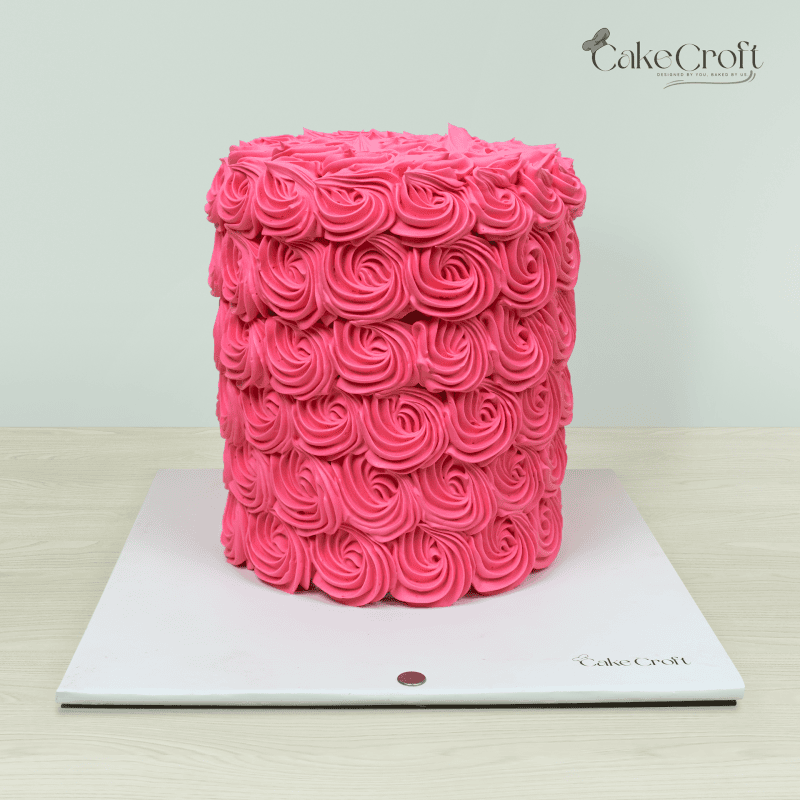 A tall, elegant pink rosette cake covered in beautifully piped buttercream roses, creating a stunning floral texture.