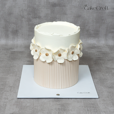 Minimalist ivory and beige floral cake with white textured flowers and gold centers