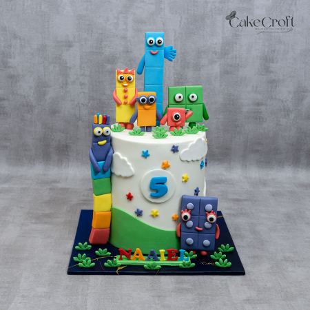 Colorful Numberblocks-themed birthday cake with fondant figures and a number "5" topper, customized with the name "Naaiel."