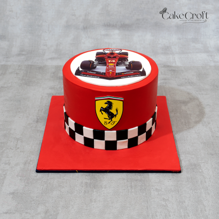 Ferrari-themed racing cake in bright red with Ferrari F1 car print, prancing horse logo, and black-and-white checkered design.