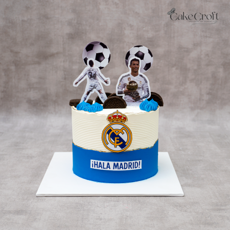 Real Madrid theme cake with Cristiano Ronaldo topper, football decorations and blue-white buttercream design by CakeCroft Dhaka.