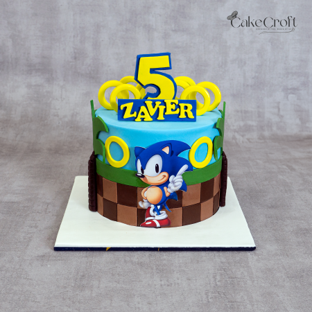 Sonic the Hedgehog-themed fondant birthday cake with golden rings, blue and green design, and “Zavier 5” topper by CakeCroft Dhaka.