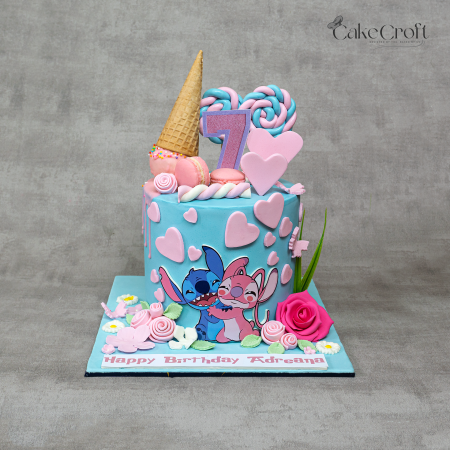 Stitch and Angel theme pastel blue birthday cake with pink hearts, lollipops, ice cream cone, and floral decorations by CakeCroft Dhaka.