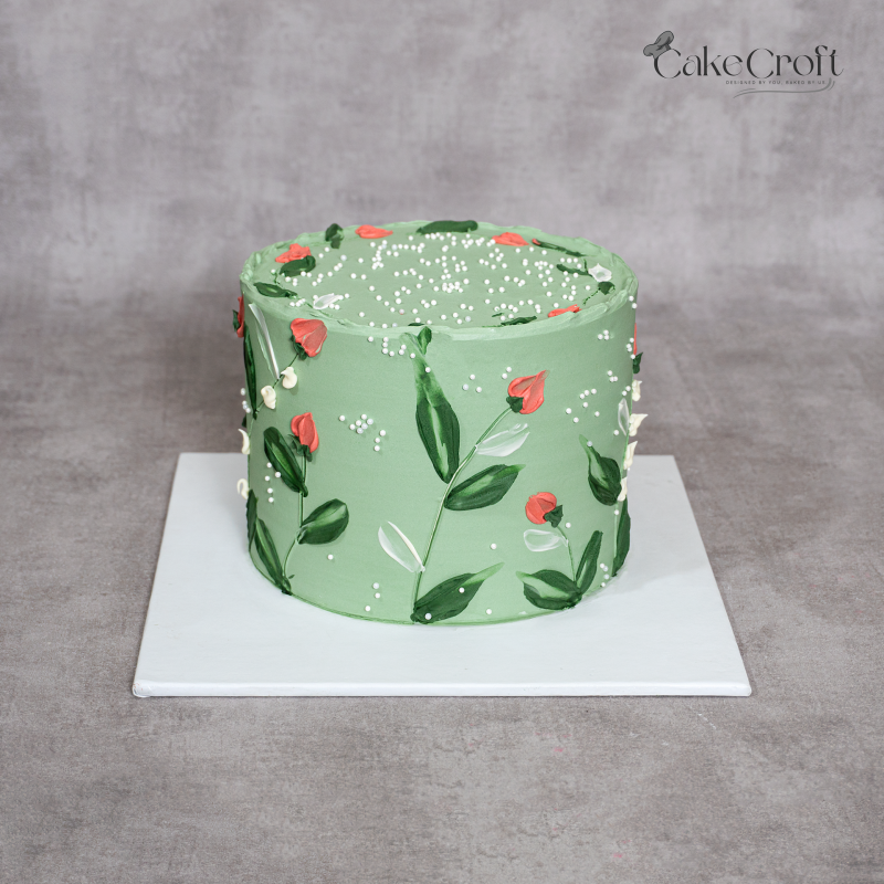 Sage green buttercream cake with hand-painted floral design and edible pearls by CakeCroft Dhaka.