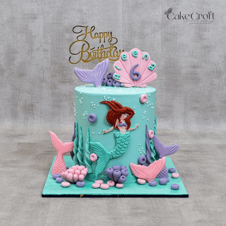 Aqua mermaid theme birthday cake with seashell name topper “Aleena 6”, seaweed fondant, pastel shells and gold Happy Birthday topper by Cakecroft.