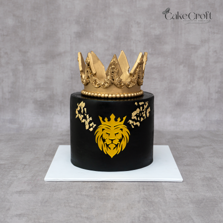 Royal black and gold crown cake with lion emblem and gold leaf detailing.