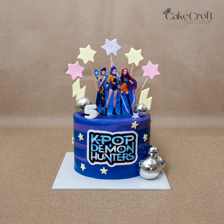 K-Pop Demon Hunters themed cake with character toppers, stars, and disco ball decorations.