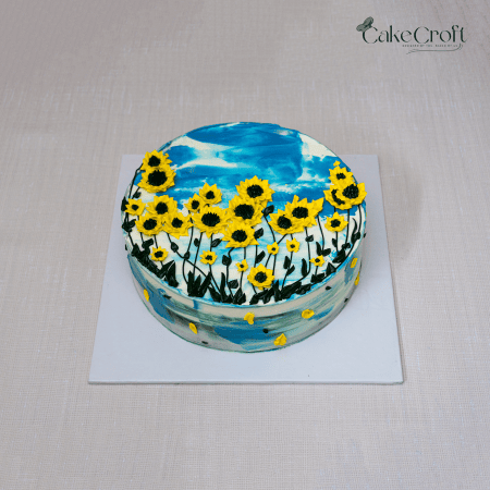 Hand-painted sunflower cake with blue sky buttercream and piped yellow flowers.