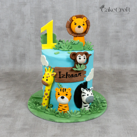 Jungle safari 1st birthday cake with lion, tiger, zebra, giraffe and monkey fondant decorations in Dhaka