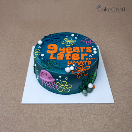 SpongeBob inspired “9 Years Later” birthday cake with underwater flowers and jellyfish decorations.