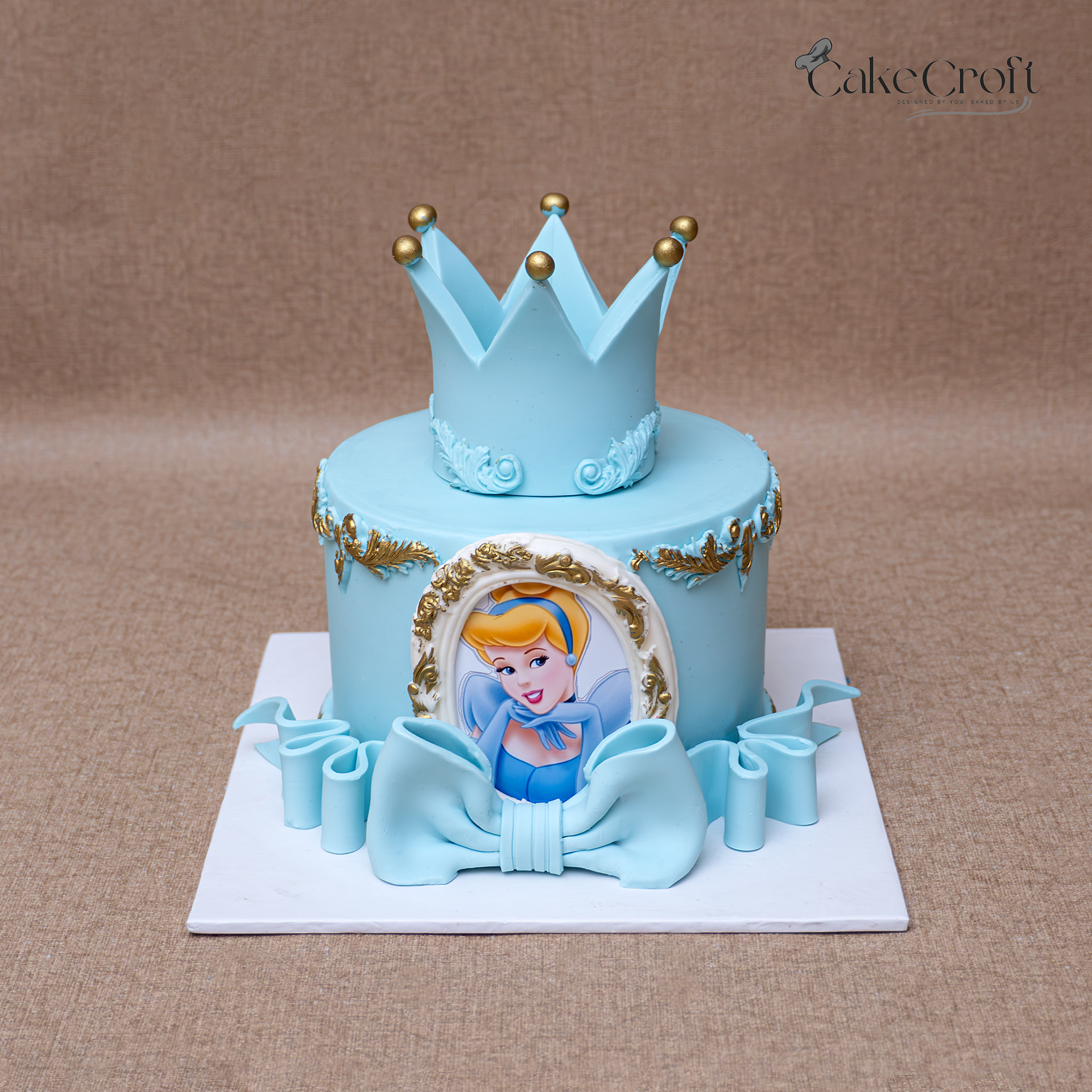 Blue princess crown cake with Cinderella theme and gold decorations