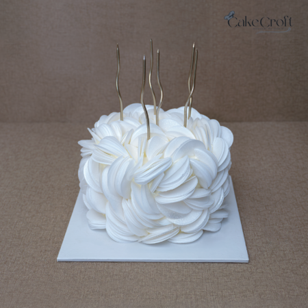 White cake with wafer paper flowers and gold toppers
